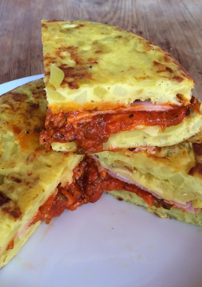 Una foto de Tortilla de patatas con jamón york y queso y salsa de tomate