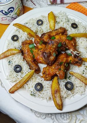 A picture of Buffalo hot wings with fried spring onions rice.