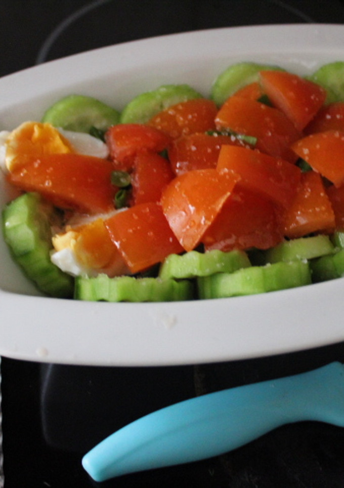 Una foto de Ensalada de canónigos, pepino, tomate y huevo