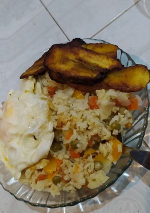 Una foto de Arroz con vegetales, plátano frito y huevo frito