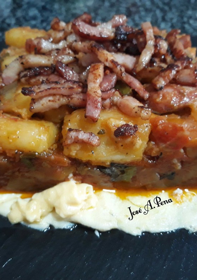 Una foto de Pisto y patatas panaderas con panceta, sobre omelette