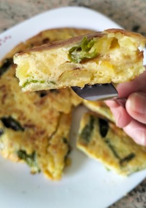 Una foto de Tortilla de patatas con cebolla y pimientos verdes