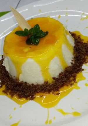 Una foto de Panna cotta de coco con coulis de flor de cempasúchil y mezcal