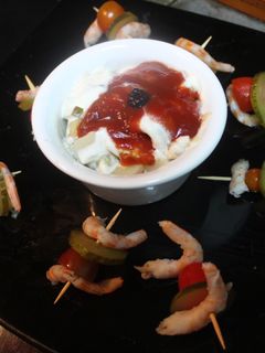 Una foto de Ensalada de filetes de arenque acompañada de pinchos de gambas