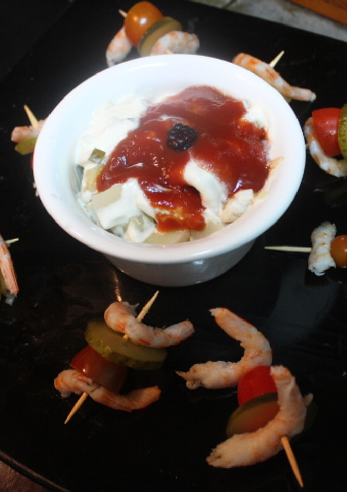 Una foto de Ensalada de filetes de arenque acompañada de pinchos de gambas