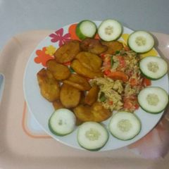 A picture of Fried plantain with fried egg and cucumber.
