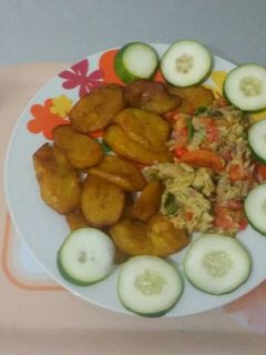 A picture of Fried plantain with fried egg and cucumber.