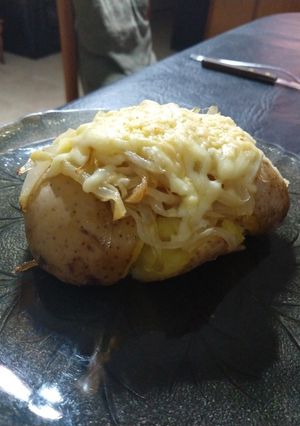 Una foto de Papas aplastadas con cebolla y queso