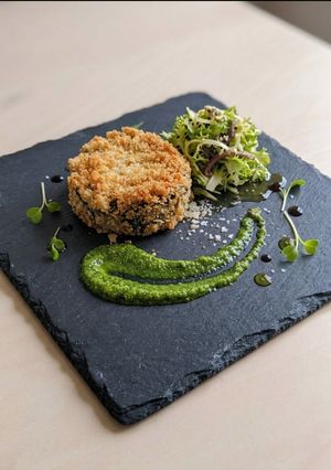 Foto di Medaglione di melanzana gratinata, salsa al basilico e indivia riccia all'acciuga