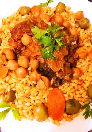 Une photo de Pâtes à la sauce rouge, et viande d'agneau،olives verts