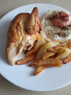 Una foto de Pollo asado con huevo frito y patatas fritas