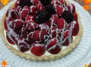 Una foto de tarta chocolate blanco y frutos rojos