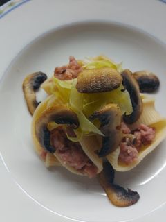 Una foto de Caracolas rellenas de carne, acompañadas de repollo y champiñones