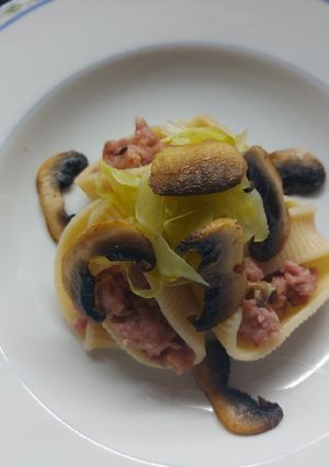 Una foto de Caracolas rellenas de carne, acompañadas de repollo y champiñones