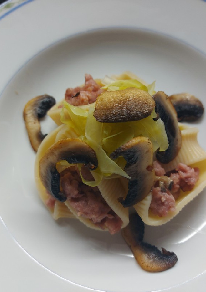 Una foto de Caracolas rellenas de carne, acompañadas de repollo y champiñones