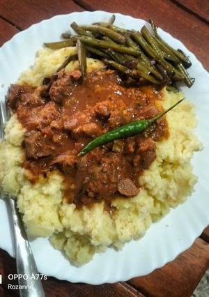 A picture of Stewed beef with creamy mashed potatoes served with sauteed buttery string beans.