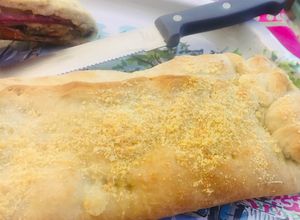 Una foto de Empanada arrollada de pastrón y quesos 🥓🫑🧀🧅