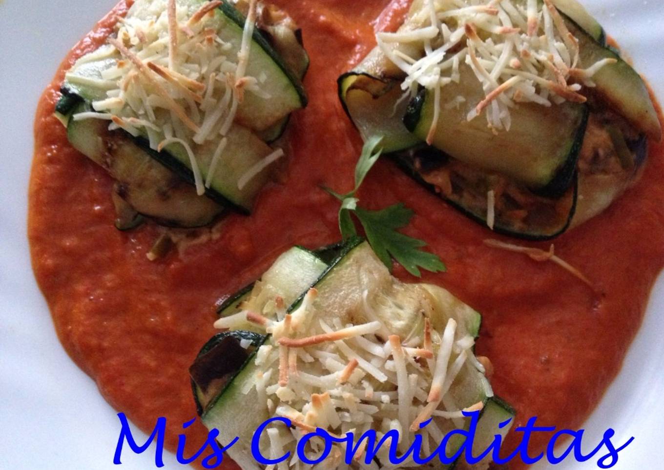 Lasaña de calabacín rellena de berenjena y queso sobre salsa de pimiento rojo