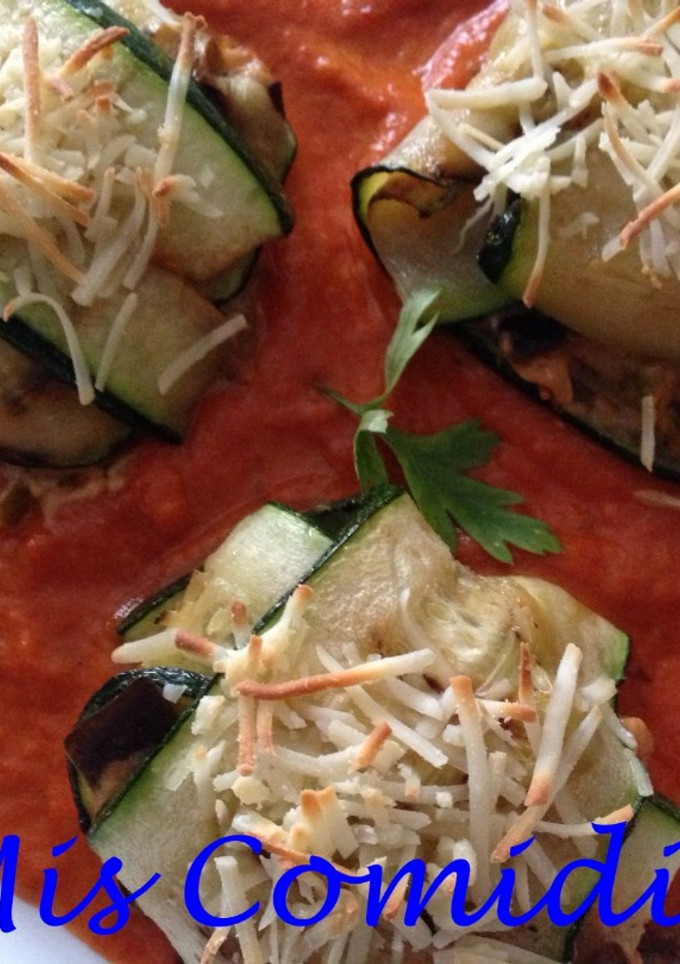 Una foto de Lasaña de calabacín rellena de berenjena y queso sobre salsa de pimiento rojo