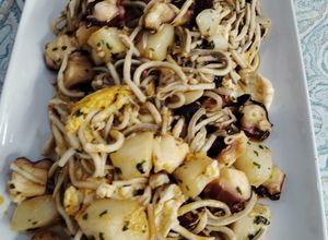 Una foto de Huevos rotos con pulpo y gulas al toque de pimentón