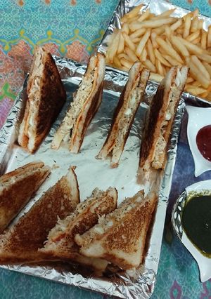 A picture of Chicken and eggs cheese sandwiches with french fries.