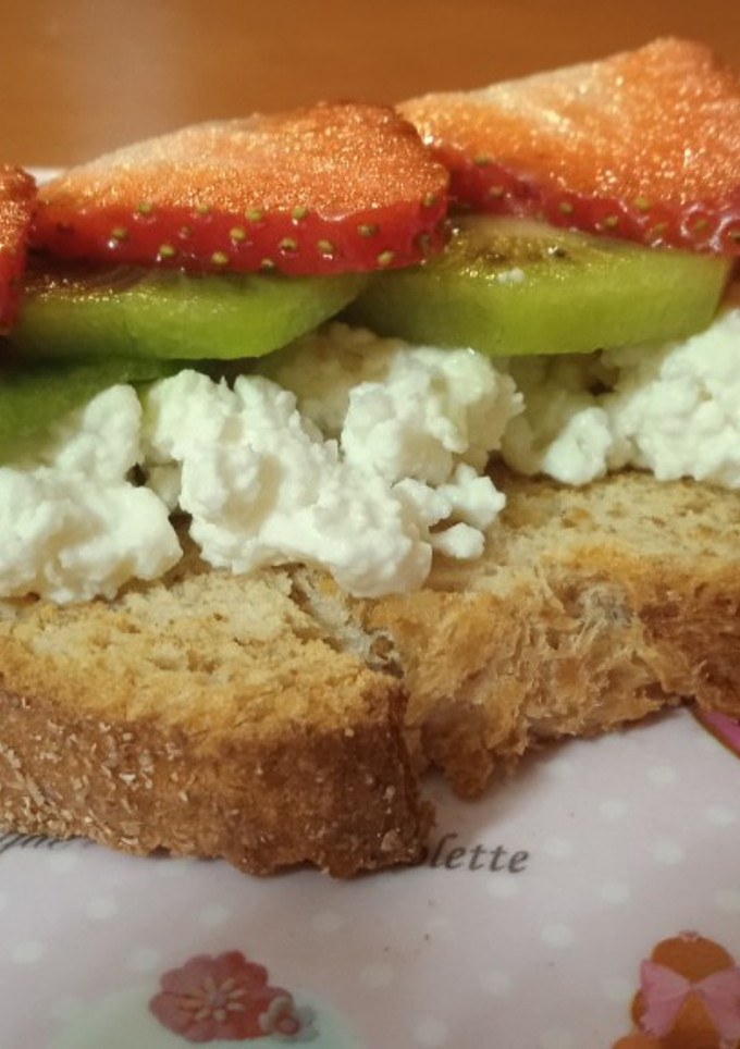 Una foto de Tostada con queso, kiwi y fresas
