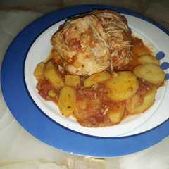 Una foto de Pollo con salsa de tomates y papas