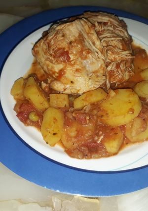 Una foto de Pollo con salsa de tomates y papas
