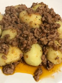 Una foto de Ñoquis rellenos de pesto, con salsa de carne insuperable