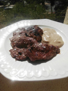 Una foto de Carrilleras a la plancha con puré de patatas y ajo negro
