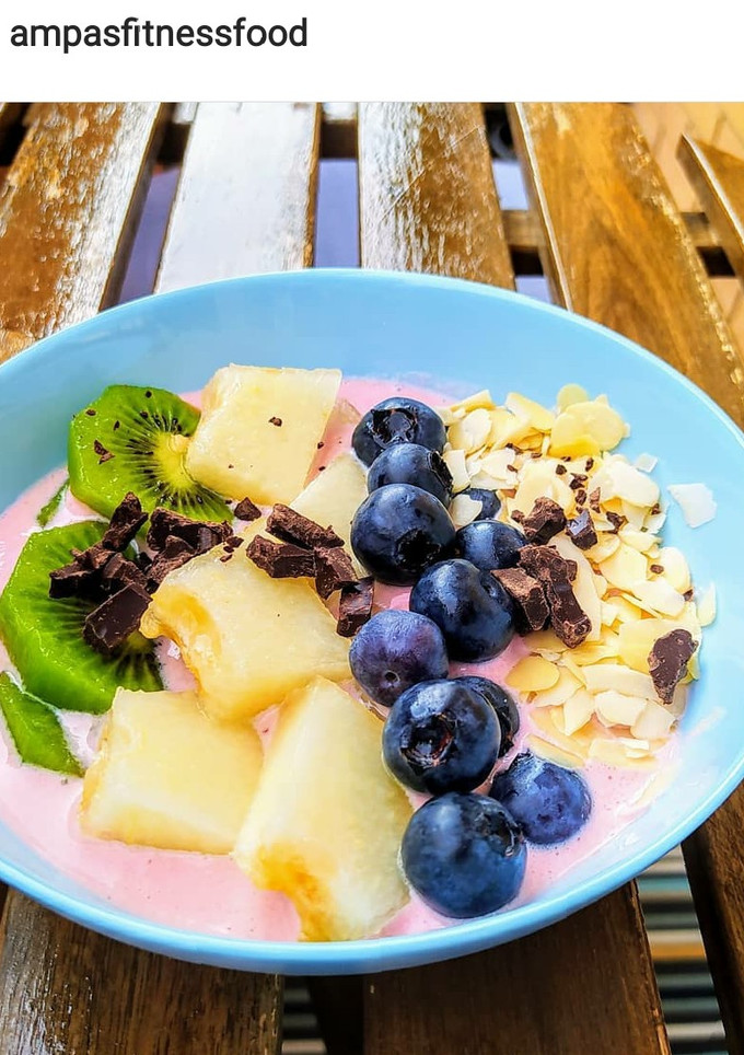 Una foto de Bowl de yogurt y fruta. Yogurt griego triturado con frambuesas