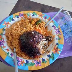 A picture of Jollof rice with grilled turkey.