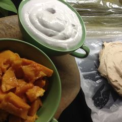 A picture of Pavlova with whipped cream and fresh mango.