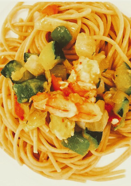 Una foto de Espaguetis integrales con verduras y gambas