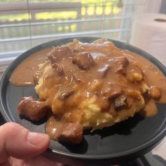 A picture of Crock pot Steak bites and gravy over mashed potatoes.