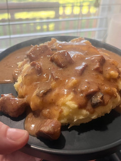 A picture of Crock pot Steak bites and gravy over mashed potatoes.