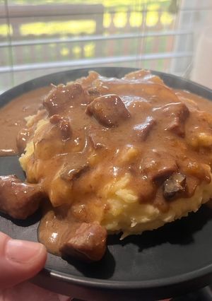A picture of Crock pot Steak bites and gravy over mashed potatoes.