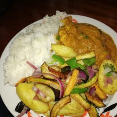 A picture of Chicken stew, roasted vegetables and rice.