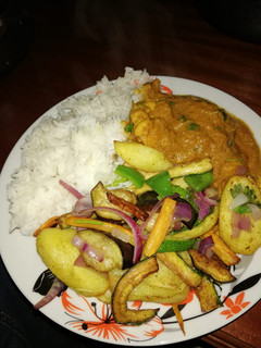 A picture of Chicken stew, roasted vegetables and rice.