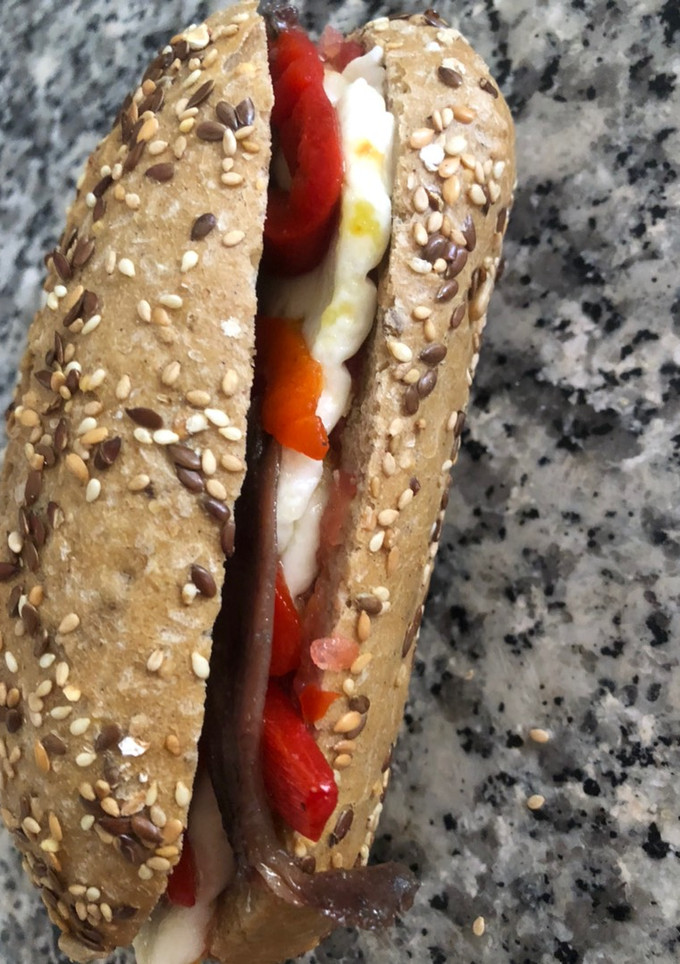 Una foto de Bocadillo con tomate, queso fresco, pimientos del piquillo y anchoas