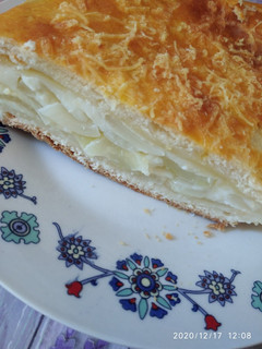 Una foto de Torta de queso, cebolla y salsa blanca