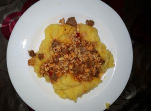 Una foto de Polenta con tuco de pollo y trozos de carne