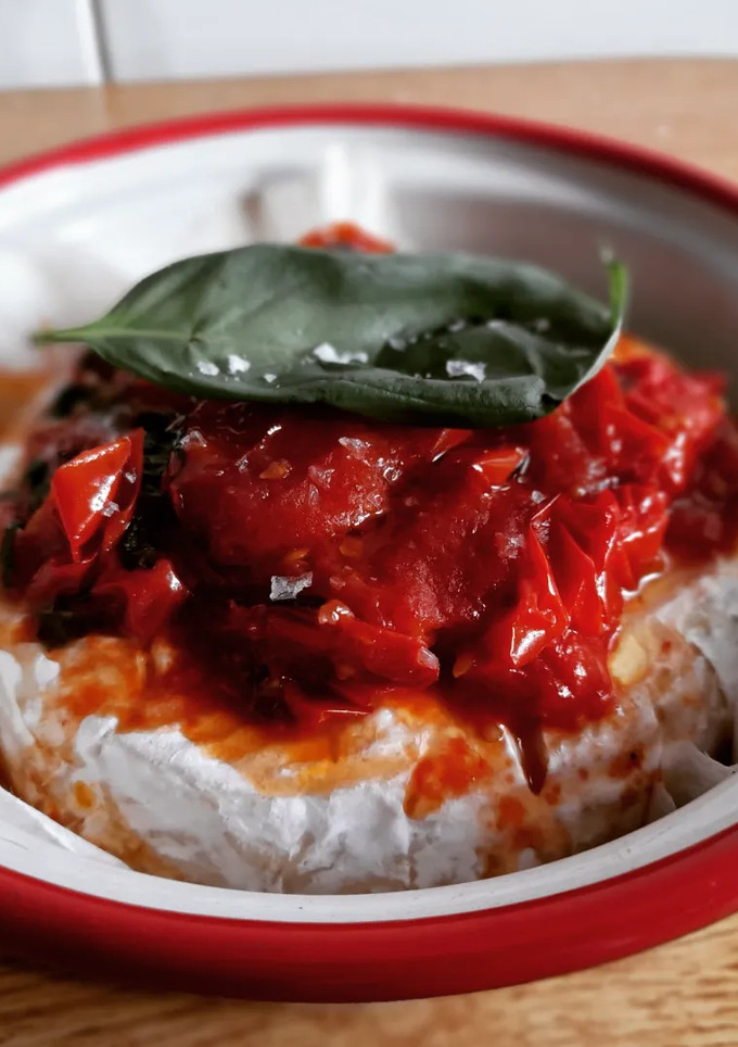 Una foto de Camembert al horno con tomate cherrys y albahaca