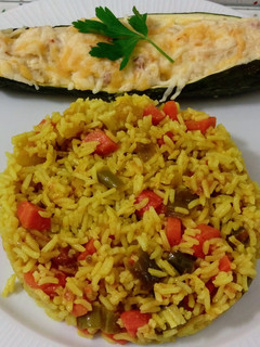 Una foto de Calabacín relleno de boniato y tofu con arroz salteado de verduras con ras el hanout