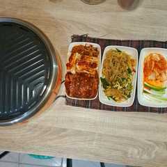 A picture of Korean Bbq homemade with Japchae and Kimchi.