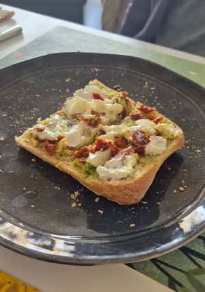 Una foto de Tostada con aguacate, burrata y tomates secos