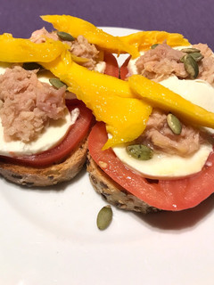 Una foto de Tostada de tomate con mozzarella, atún y mango