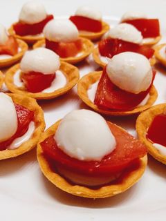 Una foto de Canapé de crema de queso curado con tomate y mozzarella