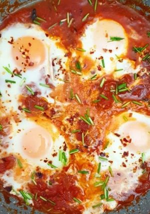 A picture of Baked egg with red sauce.