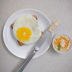 A picture of Olive oil fried egg and hummus toast.